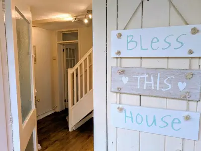 a room with a door with a sign that reads bless this house at Theatre Severn Town House, Parking & Quarry Views in Shrewsbury