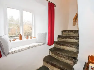 a living room with a red curtain and stairs at Tafarn Trip in Blaenau-Ffestiniog