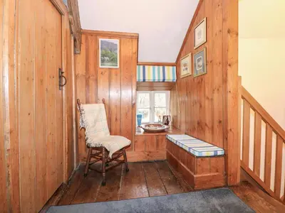a room with wooden walls and a chair and a desk at Tafarn Trip in Blaenau-Ffestiniog