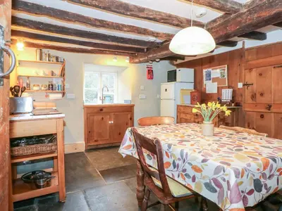 a kitchen with a table and a kitchen with wooden cabinets at Tafarn Trip in Blaenau-Ffestiniog