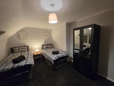 a bedroom with two beds and a large mirror at Shrewsbury Creations in Shrewsbury