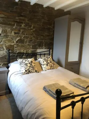 a large bed in a room with a stone wall at The Eagles Inn in Rhayader