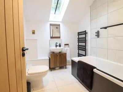 a bathroom with a sink and a tub and a toilet at Sally's Barn in Oswestry