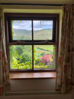 a window with a view of a flower garden at Detached cottage in the hills near Dolgellau in Cross Foxes