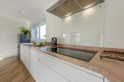 a kitchen with white cabinets and a wooden counter top at 4 Bed in Aberarth oc-g30835 in Aberaeron