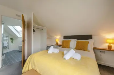 a bedroom with a large yellow bed with two pillows at 4 Bed in Aberarth oc-g30835 in Aberaeron
