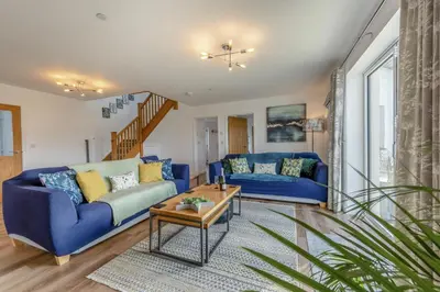 a living room with a blue couch and a table at 4 Bed in Aberarth oc-g30835 in Aberaeron
