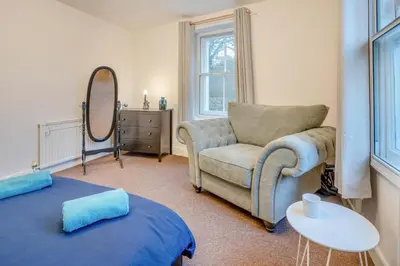 a living room with a couch and a chair and a mirror at 4 Bed in Brecon oc-h30823 in Brecon