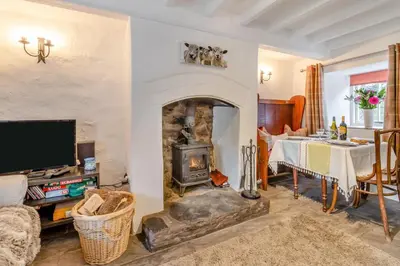 a living room with a fireplace and a dining table at 2 Bed in Llanuwchllyn oc-t30615 in Llanuwchllyn