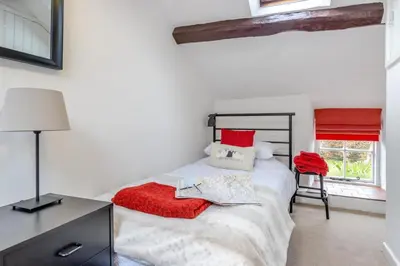 a bedroom with a bed with red pillows and a chair at 2 Bed in Llanuwchllyn oc-t30615 in Llanuwchllyn