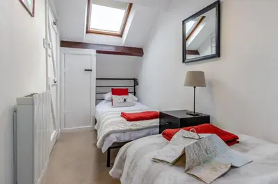 a bedroom with two beds and a mirror on the wall at 2 Bed in Llanuwchllyn oc-t30615 in Llanuwchllyn
