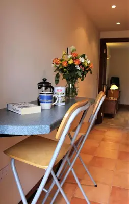 a counter with two chairs and a vase of flowers at Herdsman's Hideaway in Leominster