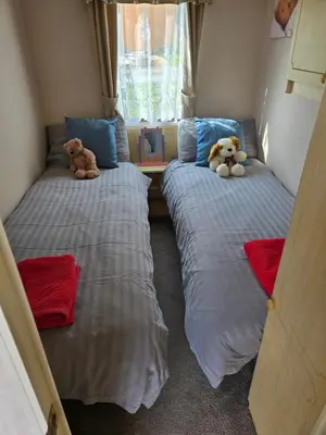 two beds with teddy bears sitting on them in a room at Homely 2 Bedrommed Mobile Home E1 in Aberystwyth
