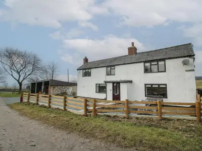 a white house with a wooden fence in front of it at The Firs in Shrewsbury
