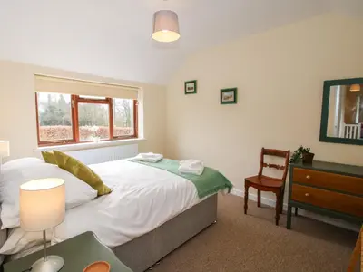 a bedroom with a bed and a desk and a window at The Firs in Shrewsbury