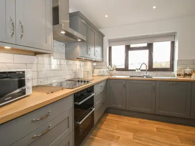 a kitchen with gray cabinets and a stove top oven at The Firs in Shrewsbury
