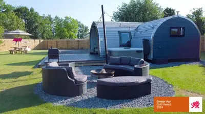 a blue tiny house with couches and a patio at The Pod at Gerycoed in Llangadog