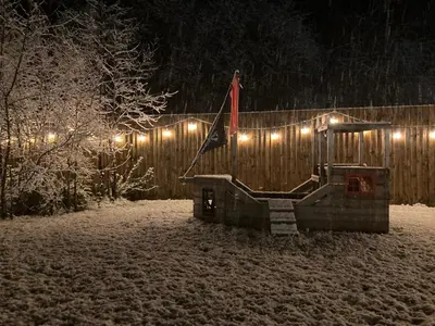 a snow covered yard with a wooden fence with lights at The Pod at Gerycoed in Llangadog