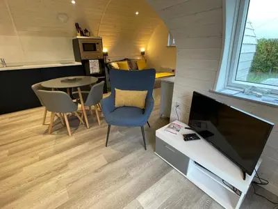 a living room with a tv and a table at The Pod at Gerycoed in Llangadog