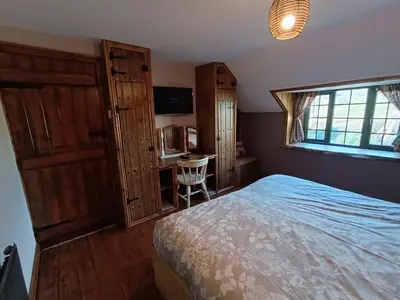 a bedroom with a bed and a desk and a window at A peaceful cottage in the countryside in Abermule