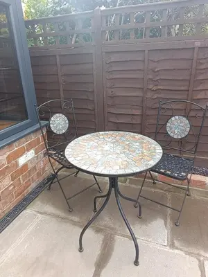 a table and two chairs on a patio at A peaceful cottage in the countryside in Abermule