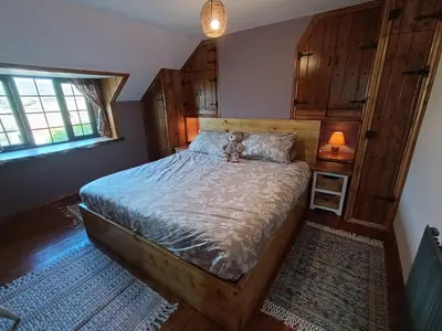 a bedroom with a bed with a teddy bear sitting on it at A peaceful cottage in the countryside in Abermule