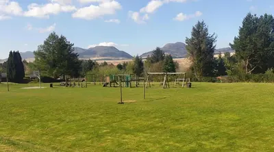 an empty park with a playground with at Misty Mountain Log Cabin - Trawsfynydd in Trawsfynydd