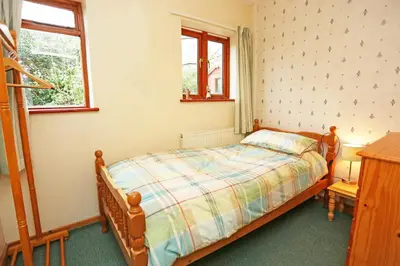 a small bedroom with a bed and a window at Artist's Cottage in Penrhyndeudreath