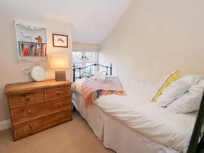 a bedroom with a bed and a dresser with a mirror at Glandwr Cottage in Llanbedr