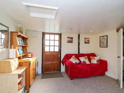 a living room with a red couch and a door at Shed Your Blues in Hereford