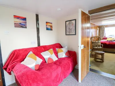 a living room with a red couch with pillows at Shed Your Blues in Hereford