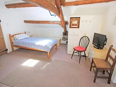 a bedroom with a bed and a desk and a tv at Y Beudy The Old Byre in Llanbedr