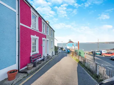 a pink building on the side of a street at Bettys Cottage in New Quay