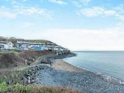 a view of a beach with houses and the ocean at Bettys Cottage in New Quay
