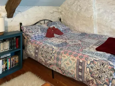 a bedroom with a bed with red shoes on it at Y Smithy - Uk49022 in Llanybydder