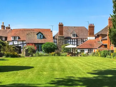 a large house with a large lawn in front of it at The Cottage in Weobley