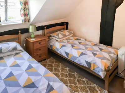 a bedroom with a twin bed and a night stand at The Cottage in Weobley