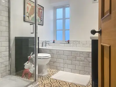 a bathroom with a toilet and a bath tub at Cosy Cwtch in Hay-on-Wye
