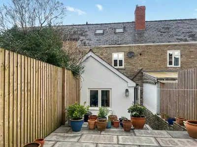 a group of potted plants in front of a fence at Cosy Cwtch in Hay-on-Wye