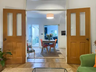 a living room with two doors and a table at Cosy Cwtch in Hay-on-Wye