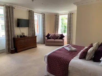 a bedroom with a bed and a couch and a television at The Trewythen in Llanidloes