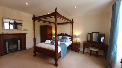 a bedroom with a canopy bed and a fireplace at The Trewythen in Llanidloes