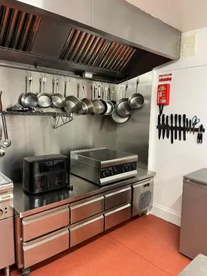 a kitchen with a stove and many pots and pans at The Trewythen in Llanidloes