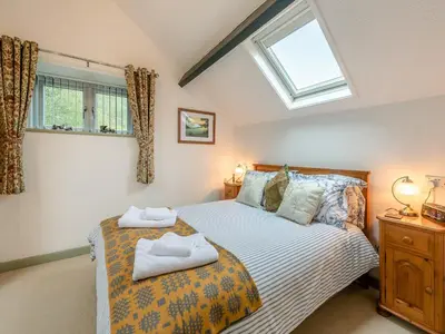 a bedroom with a bed with two towels on it at Rhydyfran Coach House in Cribyn