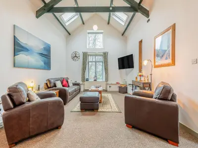 a living room with two couches and a tv at Rhydyfran Coach House in Cribyn
