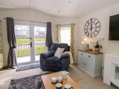 a living room with a chair and a table at 98 The Heron in New Quay