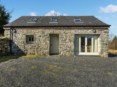 a stone house with a door and a window at Aberserw Cottage in Trawsfynydd