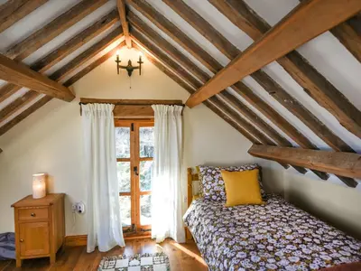 a bedroom with a bed and a window at Aberserw Cottage in Trawsfynydd