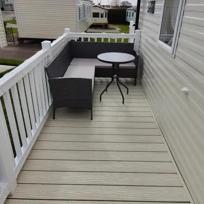 a patio with a table and a chair on a porch at Willerby Malton in Barmouth