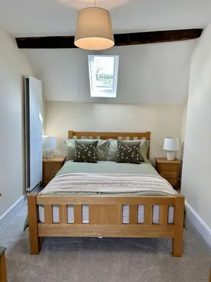 a bedroom with a large wooden bed with pillows at Tower Farm Holidays in Llangollen